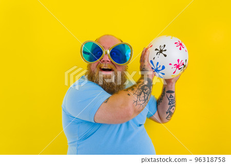 Fat man with beard and sunglasses have fun with a ball Fat man with beard and sunglasses have fun with a ball 96318758