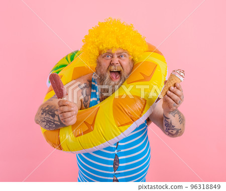 Fat man with beard and wig eats a popsicle and an icecream 96318849