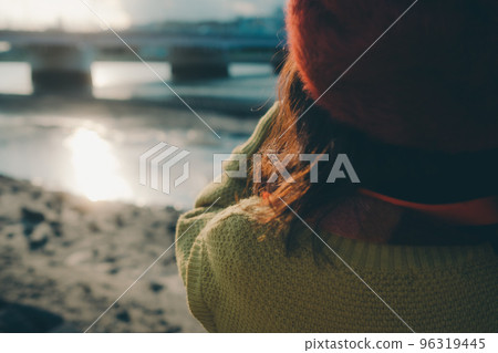 Photo of a young woman taking pictures with a camera on a riverbed 96319445