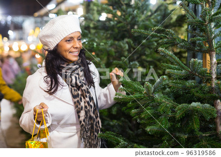 Portrait of a Latin American woman choosing a Christmas tree Portrait of a Latin American woman choosing a Christmas tree 96319586