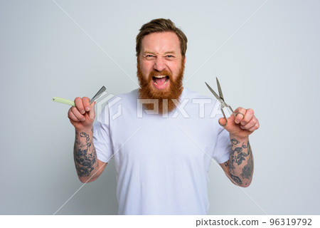 Aggressive man with scissors and blade is ready to cut the beard Aggressive man with scissors and blade is ready to cut the beard 96319792