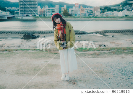 Photo of a young woman taking pictures with a single lens reflex camera on a riverbed Photo of a young woman taking pictures with a single lens reflex camera on a riverbed 96319915
