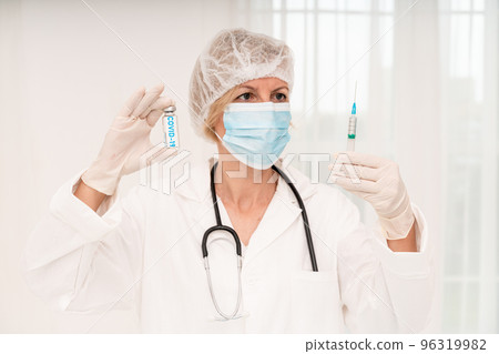 Doctor with mask and syringe is ready to administer the vaccine against covid 19 96319982