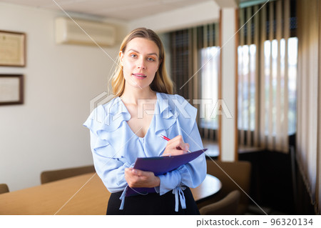 Portrait of woman holding folder in hands 96320134