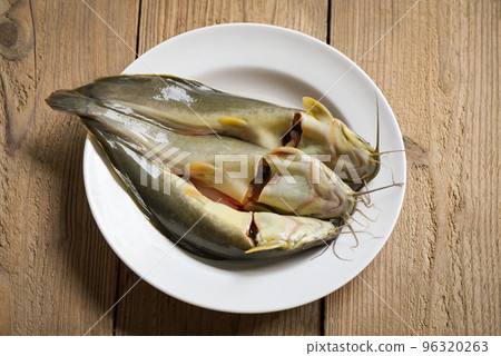 catfish on plate, fresh raw catfish freshwater fish, catfish for cooking food, fish on wooden in the kitchen catfish on plate, fresh raw catfish freshwater fish, catfish for cooking food, fish on wooden in the kitchen 96320263