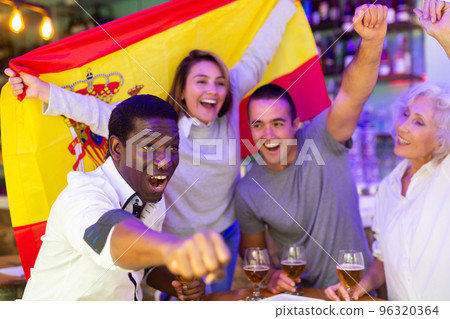 Diverse group celebrating with Spanish flag Diverse group celebrating with Spanish flag 96320364
