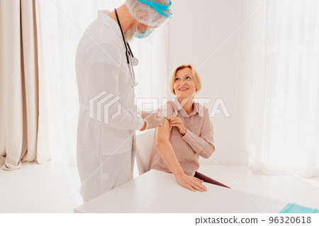 Doctor with mask and syringe is ready to administer the vaccine against covid 19 Doctor with mask and syringe is ready to administer the vaccine against covid 19 96320618