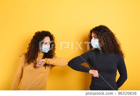 Friends stay away to avoid contact and contagion of the virus. Concept of codiv-19 rules to avoid pandemic. yellow background Friends stay away to avoid contact and contagion of the virus. Concept of codiv-19 rules to avoid pandemic. yellow background 96320656