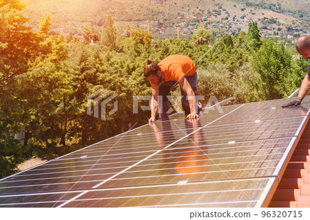 Workers assemble energy system with solar panel for electricity Workers assemble energy system with solar panel for electricity 96320715