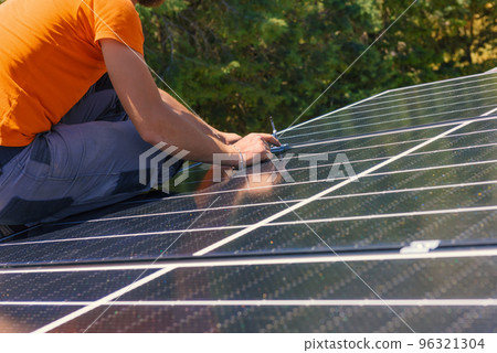 Workers assemble energy system with solar panel for electricity and hot water 96321304