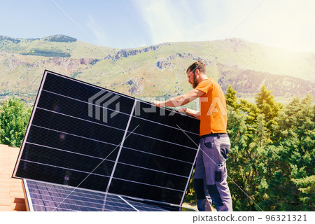 Workers assemble energy system with solar panel for electricity and hot water Workers assemble energy system with solar panel for electricity and hot water 96321321