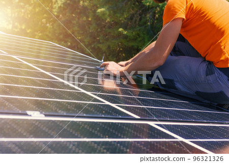 Workers assemble energy system with solar panel for electricity and hot water 96321326