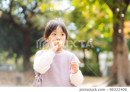 Girls playing with soap bubbles 96322406