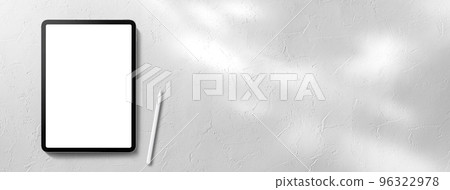 平板電腦和触摸筆放置在白色空間中，陽光透過樹木過濾 96322978