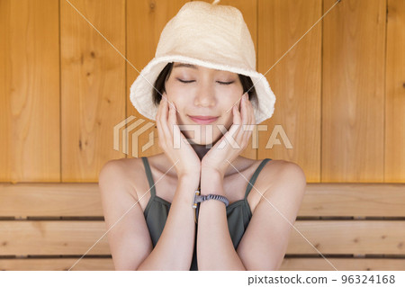 一位戴著桑拿帽進入桑拿房的年輕女子 96324168