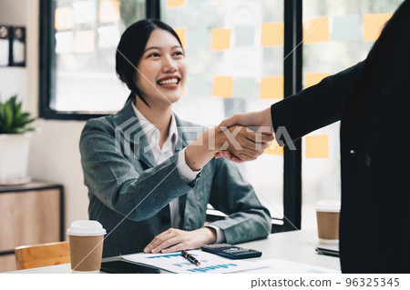 Welcome to our team. close up young modern women shaking hands while working in the creative office 96325345