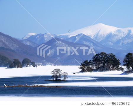 Urabandai in winter, Lake Akimoto. The collaboration of the blue lake water, the white snow field, and the snow-capped Mt. Minowa is beautiful. 96325672