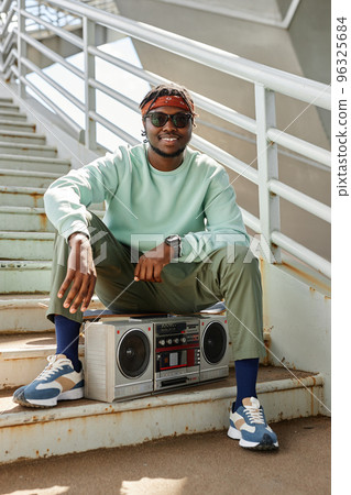 Young black man wearing street style clothes with boombox 96325684