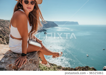 Digital nomad, Business woman working on laptop by the sea. Pretty lady typing on computer by the sea at sunset, makes a business transaction online from a distance. Freelance, remote work on vacation Digital nomad, Business woman working on laptop by the sea. Pretty lady typing on computer by the sea at sunset, makes a business transaction online from a distance. Freelance, remote work on vacation 96325861