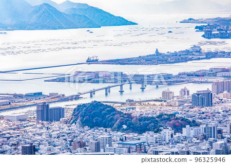 Hiroshima Hatsukaichi Ohashi Bridge and Miyajima, Hatsukaichi City, and Itsukaichi harbor area are viewed. You can see the forest of Ebiyama-cho in the foreground. 96325946