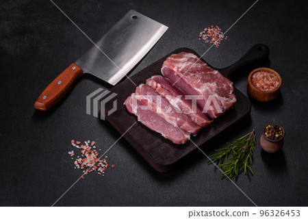 Fresh piece of raw pork with spices, salt and herbs on a wooden cutting board Fresh piece of raw pork with spices, salt and herbs on a wooden cutting board 96326453