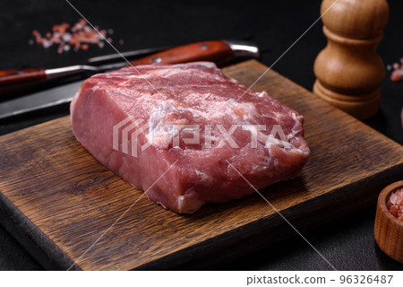 Fresh piece of raw pork with spices, salt and herbs on a wooden cutting board Fresh piece of raw pork with spices, salt and herbs on a wooden cutting board 96326487