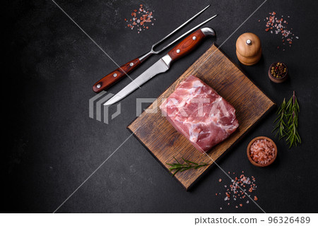 Fresh piece of raw pork with spices, salt and herbs on a wooden cutting board Fresh piece of raw pork with spices, salt and herbs on a wooden cutting board 96326489