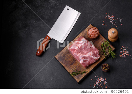 Fresh piece of raw pork with spices, salt and herbs on a wooden cutting board 96326491
