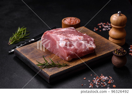 Fresh piece of raw pork with spices, salt and herbs on a wooden cutting board Fresh piece of raw pork with spices, salt and herbs on a wooden cutting board 96326492
