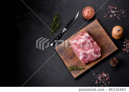 Fresh piece of raw pork with spices, salt and herbs on a wooden cutting board Fresh piece of raw pork with spices, salt and herbs on a wooden cutting board 96326493