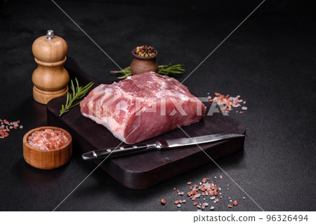 Fresh piece of raw pork with spices, salt and herbs on a wooden cutting board Fresh piece of raw pork with spices, salt and herbs on a wooden cutting board 96326494