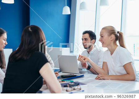 Students gather around table and talk while studying Students gather around table and talk while studying 96326987