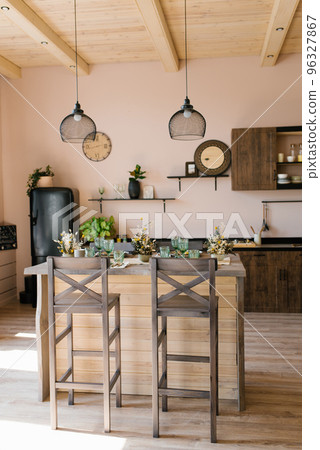 The interior of the living room of a country house made of wood in the Scandinavian style. Bar table with chairs and kitchen 96327867
