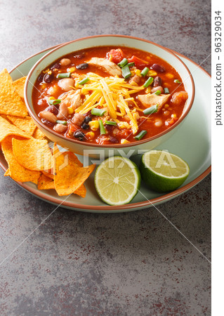 Hearty chicken taco soup packed with black beans, corn, and tomatoes with green chile peppers close-up in a plate. Vertical 96329034