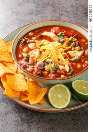 Taco chicken soup served with lime and tortilla chips close-up in a plate. Vertical Taco chicken soup served with lime and tortilla chips close-up in a plate. Vertical 96329035