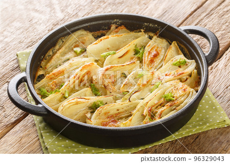 Baked fennel root with parmesan cheese and bechamel sauce close-up in a frying pan. Horizontal 96329043