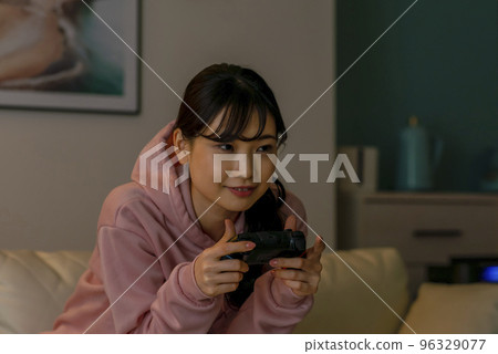 Young woman playing online games at night 96329077