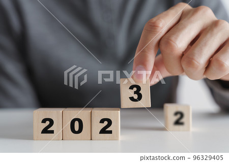 Man hand putting wooden cube block to change 2022 year to 2023 year. start to year 2023. happy new years concept. 96329405