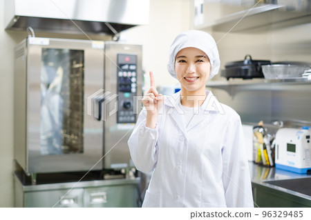 Young female cook (pointing pose) 96329485