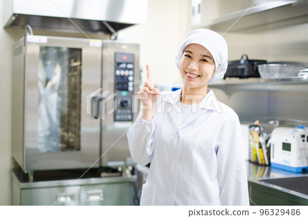 Young female cook (pointing pose) 96329486