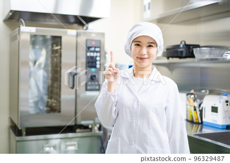 Young female cook (pointing pose) 96329487