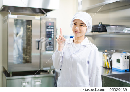 Young female cook (pointing pose) 96329489