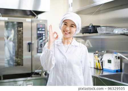 年輕女廚師（OK 標誌） 96329505