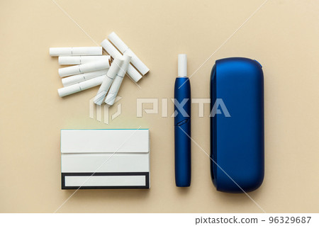 Iqos electronic blue cigarette on a beige background. Iqos electronic blue cigarette on a beige background. 96329687