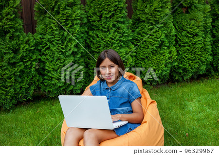 girl with a laptop in the garden girl with a laptop in the garden 96329967