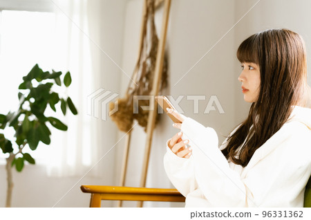 A young woman who feels tired looking at her smartphone 96331362