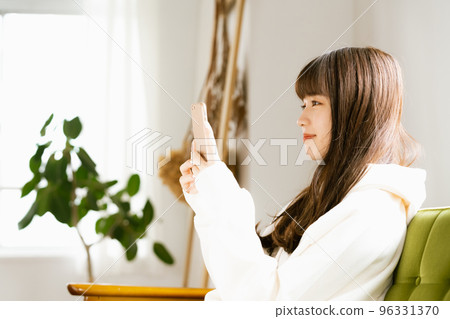 一位看著智能手機感到疲倦的年輕女性 96331370