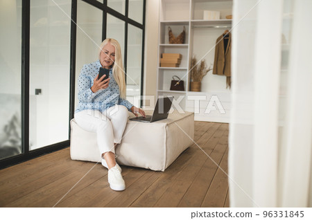 Blonde smiling woman having a call and looking peaceful Blonde smiling woman having a call and looking peaceful 96331845