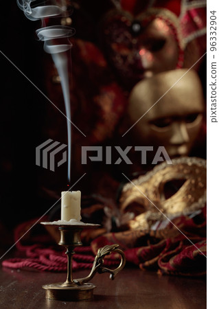 Still life with an extinguished candle and carnival masks. 96332904