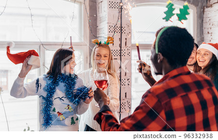 Friends with sparklers in hands. Group of friends celebrating Christmas eve together. Friends with sparklers in hands. Group of friends celebrating Christmas eve together. 96332938